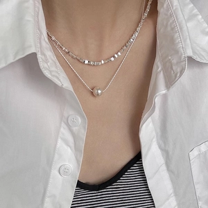 Double-layered silver necklace with irregular beads and a round pearl pendant for women