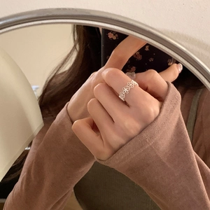 Detailansicht eines silbernen Rings mit hohlem Gänseblümchen-Muster im Spiegel-Selfie