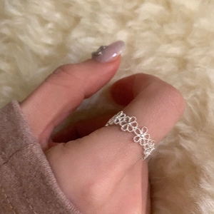 Nahaufnahme eines minimalistischen silbernen Hohlblumen-Spitzenrings am Daumen