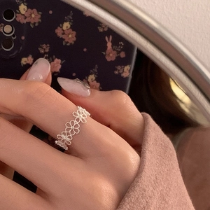 Detailansicht eines filigranen silbernen Rings mit durchbrochenem Blumenmuster