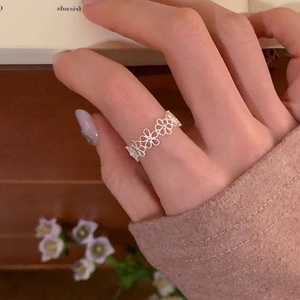 Nahaufnahme des filigranen hohlen Blumenmusters auf einem minimalistischen Silberring