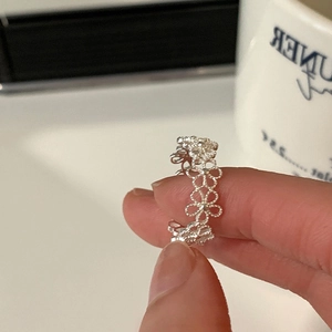 Detailansicht eines silbernen Rings mit hohlem Blumendesign und poliertem Finish