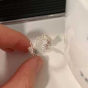 Detailansicht eines silbernen Rings mit hohlgeformtem Blumenmuster und Gravur