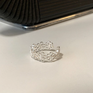 Detail des silbernen Ringes mit hohlen Blumen, S925-Stempel und floralem Metallwerk