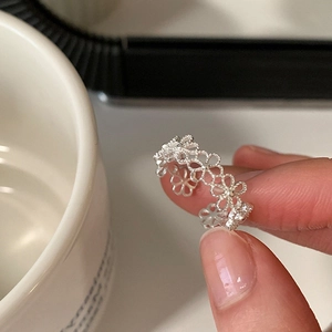 Minimalistischer silberner Ring mit hohlen Blumen und verstellbarer Bandgröße