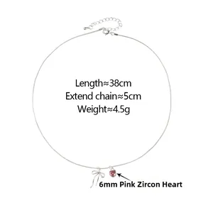 Close-up of silver bow necklace with a 6mm pink zircon heart pendant and chain details