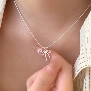 Elegant silver snake chain necklace featuring a bow pendant and pink heart zircon stone
