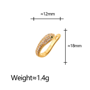 Dettaglio macro di earcuff a serpente placcato oro con zirconi bianchi e gemma verde