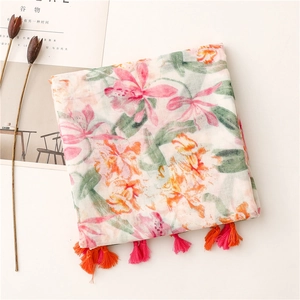 Detailed macro of vintage floral scarf with pink and orange tassels on a soft fabric