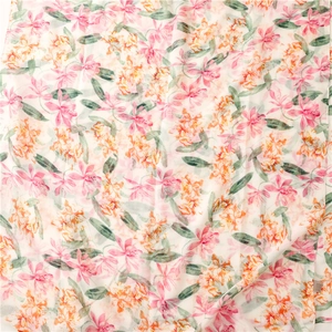 Detail view of lightweight floral print scarf with pink and orange patterns and hemmed edges
