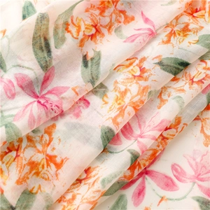 Detailed macro view of soft floral print fabric with pink blossoms and green leaves