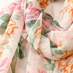 Macro detail of breathable floral printed scarf with pink flowers on creamy white fabric