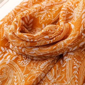 Close-up of bright orange paisley scarf with delicate sequins and soft linen texture