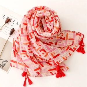 Ethnic geometric block patterned long scarf with red tassel trim on a white background