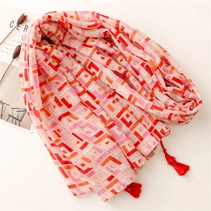 Ethnic geometric print summer sun shawl scarf with red tassels on beige background