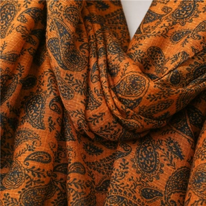 Dettaglio della trama della sciarpa in cotone paisley arancione con trama morbida