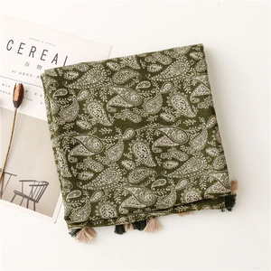 Dettaglio del motivo paisley vintage su sciarpa verde oliva con nappe fatte a mano