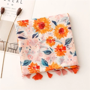 Detail of floral print scarf with orange sunflower patterns and soft fringe tassels