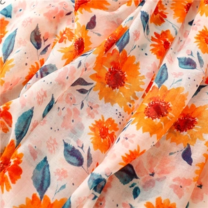 Close-up of lightweight floral cotton scarf fabric with sunflower and fringe details