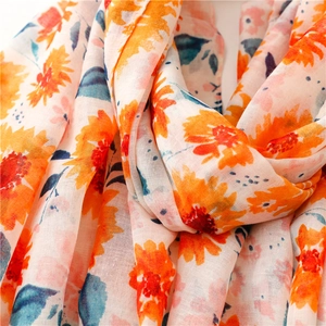 Detail shot of vibrant orange sunflower print on lightweight cotton linen summer scarf