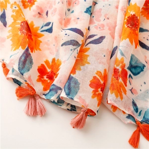 Detail of floral print scarf showing sunflower patterns and colorful tassel fringes