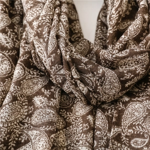 Dettaglio del motivo paisley e consistenza morbida della sciarpa in cotone marrone