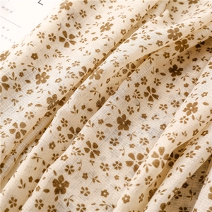 Dettaglio di tessuto in lino con motivo floreale vintage beige e trama piatta