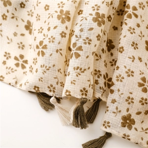 Dettaglio di sciarpa vintage in cotone e lino con stampa floreale e nappe sfrangiate