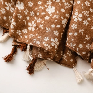 Dettaglio sciarpa in lino floreale vintage con trama del tessuto e nappe a mano
