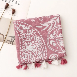 Detail of pink paisley scarf with white floral patterns and soft tassel fringe edges