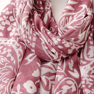 Detail view of cotton linen scarf showing dark red floral patterns and textured fabric