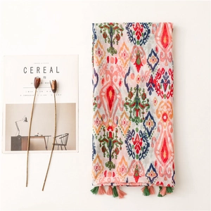 Bohemian ikat print scarf with colorful tassels on minimalist white background