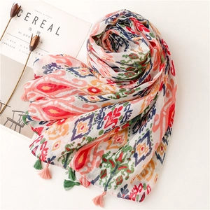 Close-up of bohemian geometric scarf featuring colorful prints and handmade pink tassels
