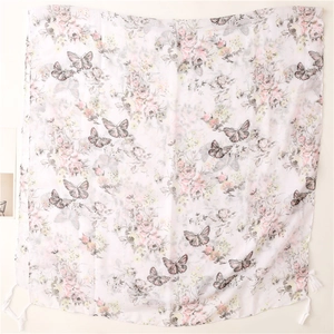 Detailed view of white cotton-linen scarf with pink flowers, butterflies and tassels