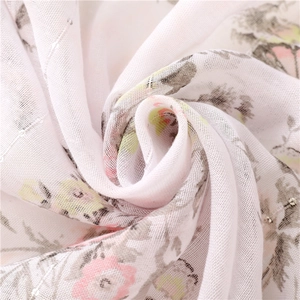 Detail of white cotton-linen feel scarf with floral print and sparkling silver sequins