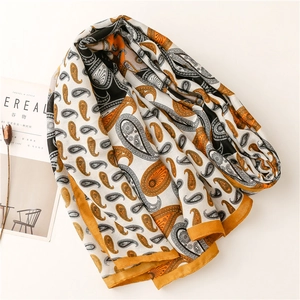 Détail d'un châle en coton et lin orange et noir avec motif cachemire et texture douce