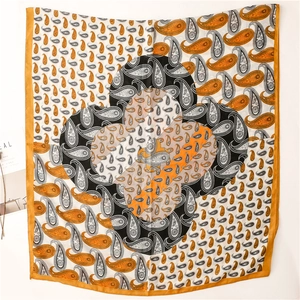 Vue détaillée du motif paisley orange et noir sur le tissu léger de l'écharpe