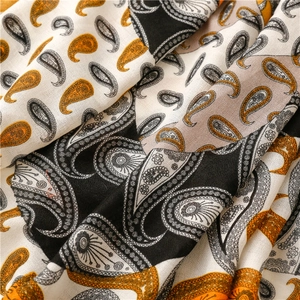 Détail de l'écharpe à motif cachemire avec texture douce en tons moutarde et noir