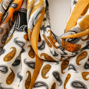 Détail du motif paisley jaune et noir sur une écharpe tendance en coton et lin doux