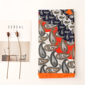 Détail d'une écharpe en coton et lin à motif paisley avec bordure orange et style vintage
