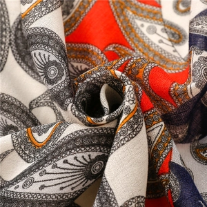 Détail d'une écharpe en lin avec motif paisley aux couleurs orange et bleu éclatantes