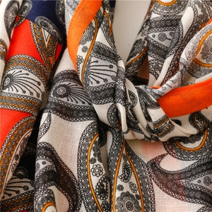 Vue macro d'une écharpe à motif cachemire aux tons orange et bleu avec texture tissée