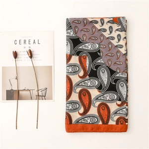 Détail d'un châle en paisley aux motifs orange et violets vifs à côté d'un décor