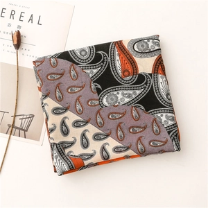 Gros plan d'une écharpe à motif cachemire avec un design patchwork rétro noir et orange