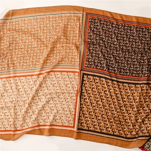 Flat lay of retro floral square scarf with four-panel layout and soft fringed edges
