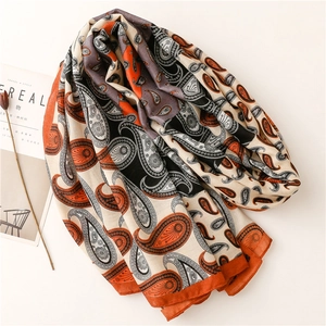 Texture détaillée d'une écharpe en coton et lin avec motif paisley orange et noir élégant