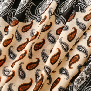 Détail macro du motif paisley sur écharpe en coton-lin doux dans les tons beige et orange