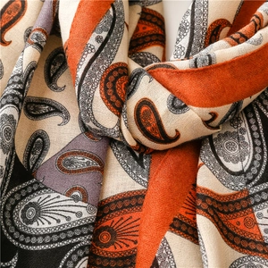 Gros plan d'une écharpe à motif cachemire avec texture tissée orange et beige