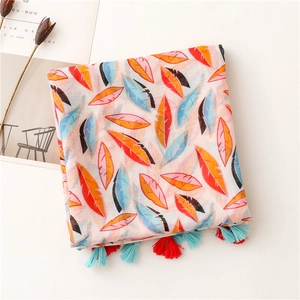 Vue détaillée d'une écharpe à motifs de plumes colorées avec franges et texture coton-lin