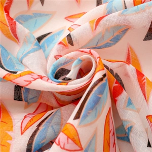 Écharpe aspect lin avec imprimés plumes colorées et pompons disposés en spirale